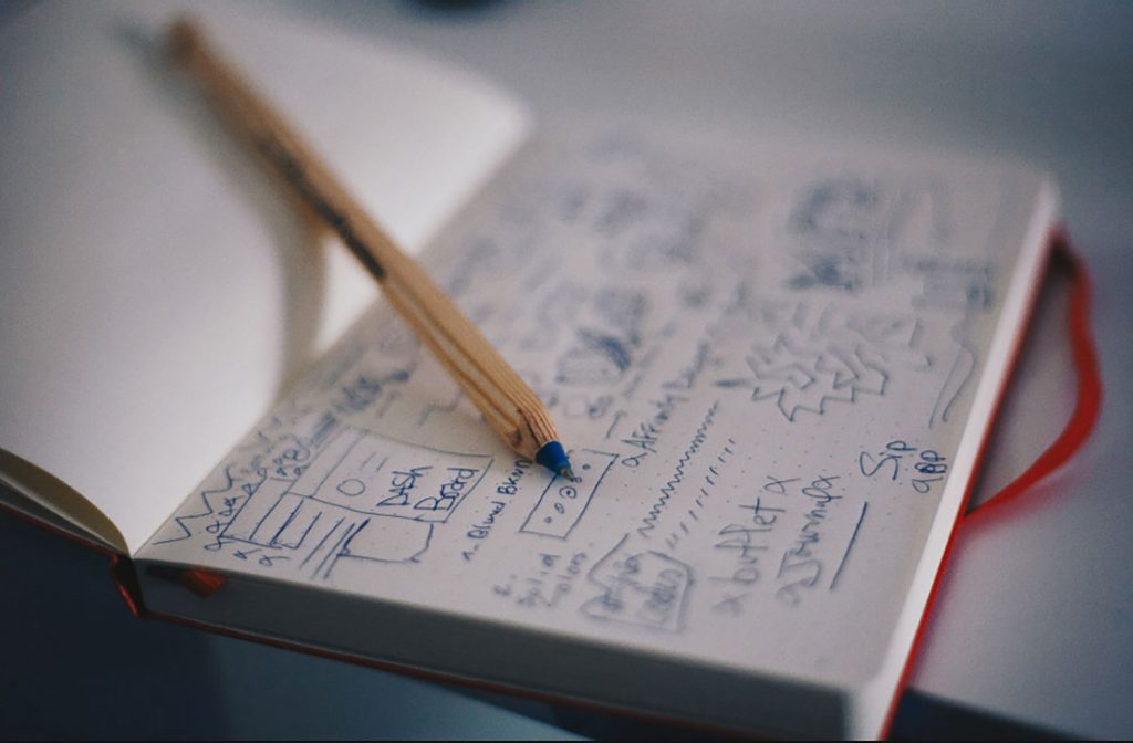 Aufgeschlagenes Notizbuch mit Skizzen und Bleistift