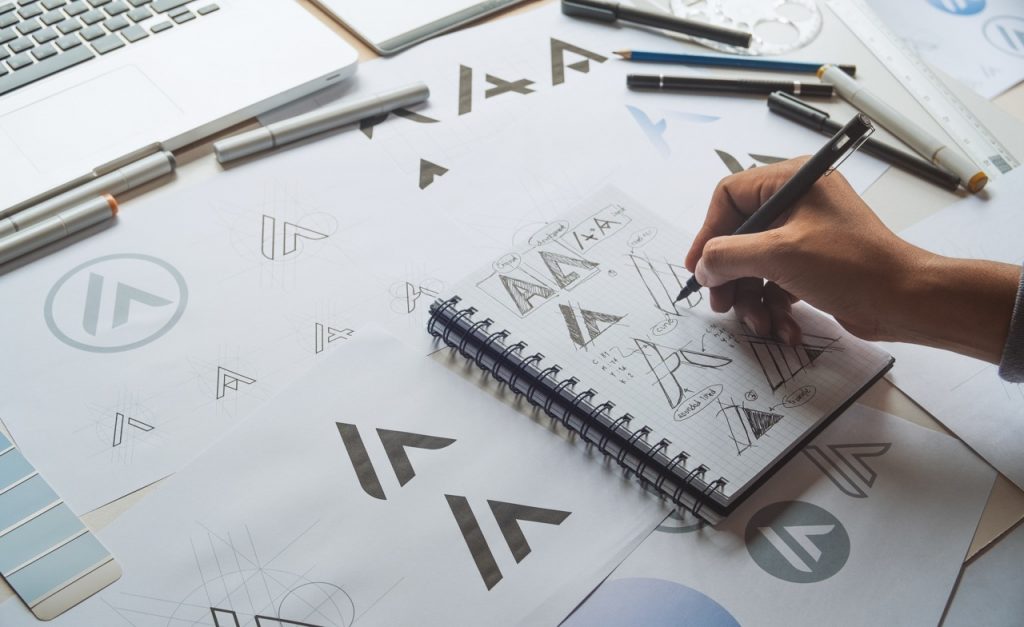 Hand skizziert Logoentwürfe in einem Notizbuch