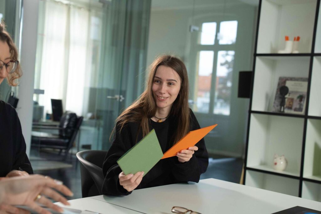 Mitarbeiterin mit grünen und orangefarbenen Karten im Büro